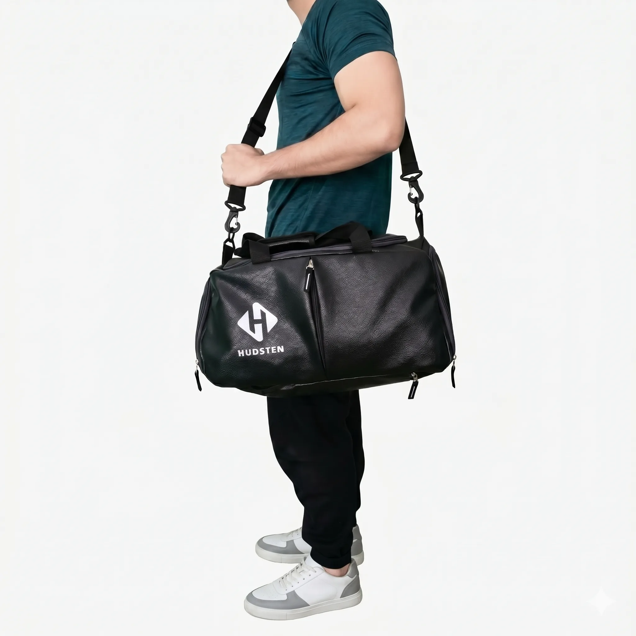 Man carrying the black Hudsten gym duffel over his shoulder by the strap